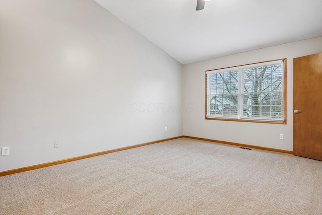 carpeted empty room featuring vaulted ceiling