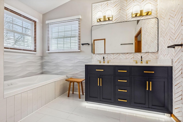 bathroom with vanity, a relaxing tiled tub, and vaulted ceiling