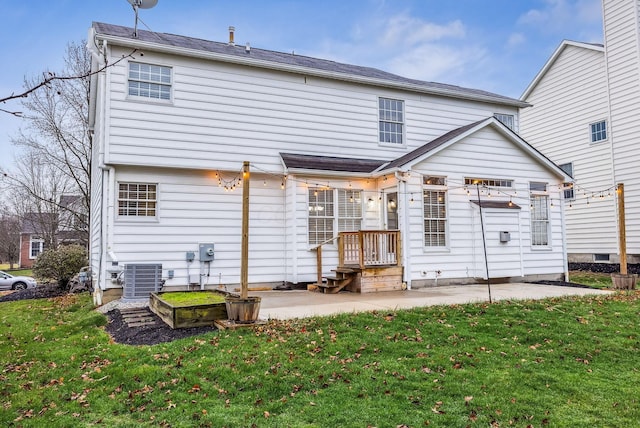 rear view of property featuring a patio, central AC, and a lawn