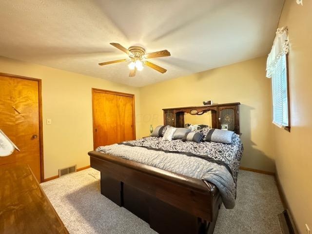 carpeted bedroom featuring a closet and ceiling fan