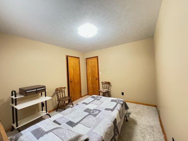 carpeted bedroom with a textured ceiling