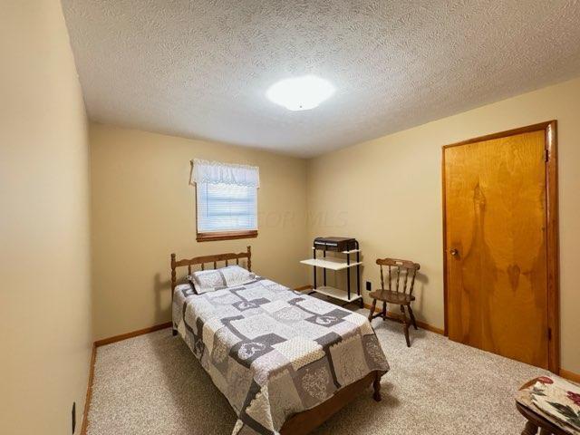 carpeted bedroom featuring a textured ceiling