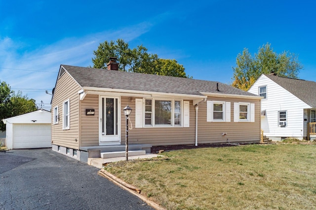 view of front of house featuring an outbuilding, a front lawn, and a garage