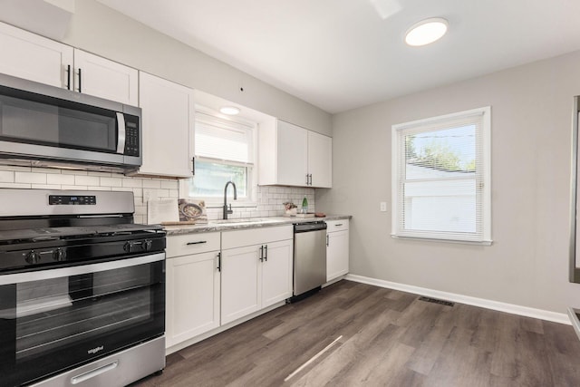 kitchen featuring sink, tasteful backsplash, dark hardwood / wood-style flooring, white cabinetry, and stainless steel appliances