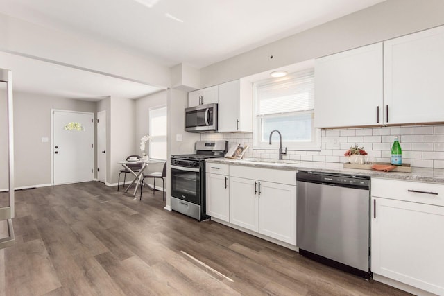 kitchen featuring white cabinets, a wealth of natural light, sink, and appliances with stainless steel finishes