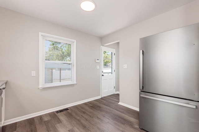 unfurnished dining area with dark wood-type flooring