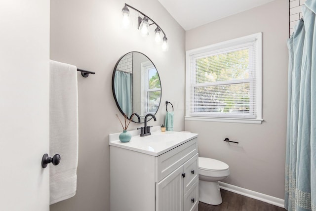 bathroom with hardwood / wood-style floors, vanity, and toilet