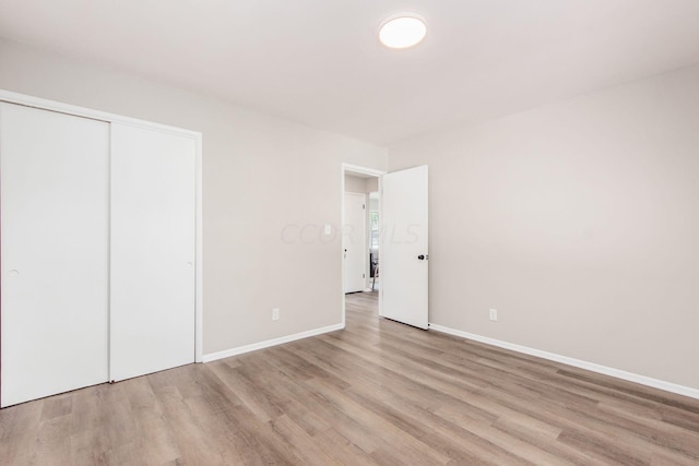 unfurnished bedroom featuring light hardwood / wood-style floors and a closet