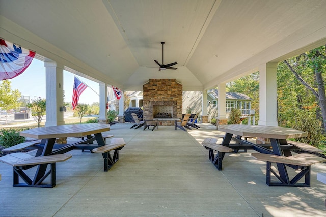 view of patio featuring an outdoor stone fireplace and ceiling fan