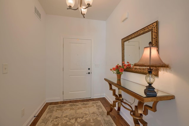 doorway with a chandelier and hardwood / wood-style flooring