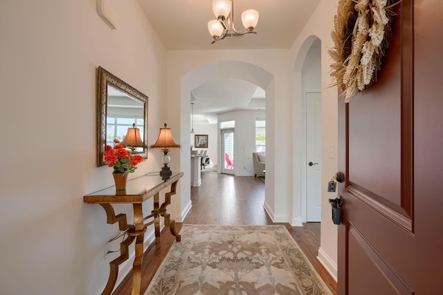 hallway featuring a chandelier and hardwood / wood-style flooring