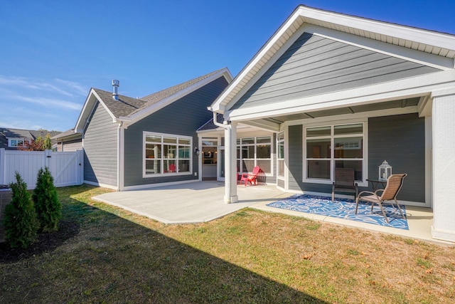 back of house featuring a patio area and a lawn