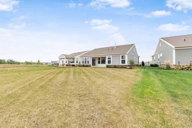 rear view of house featuring a lawn