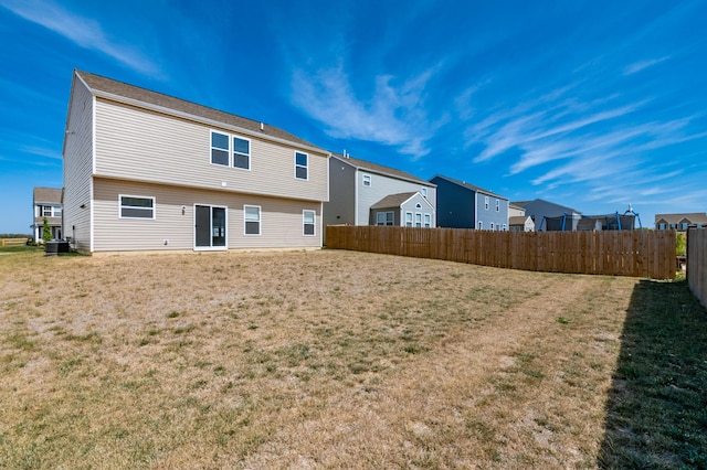 back of property featuring a lawn and central AC unit