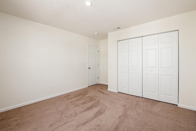 unfurnished bedroom featuring carpet flooring and a closet