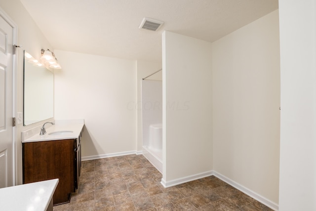 bathroom featuring a shower and vanity