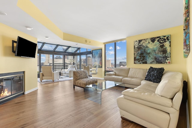 living room with a wall of windows and wood-type flooring