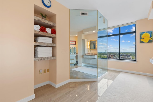 bathroom with built in shelves, vanity, and tile patterned floors