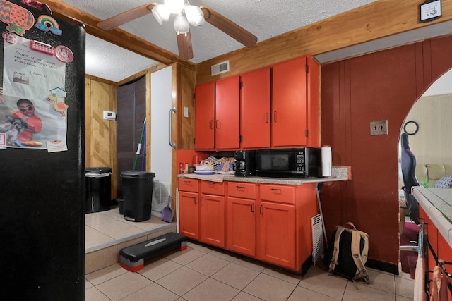 kitchen featuring a textured ceiling, ceiling fan, and light tile patterned flooring