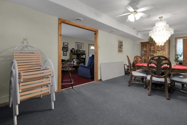 carpeted dining area with ceiling fan with notable chandelier and a textured ceiling