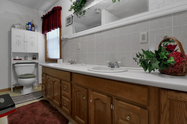 bathroom with vanity, toilet, a textured ceiling, and tile walls