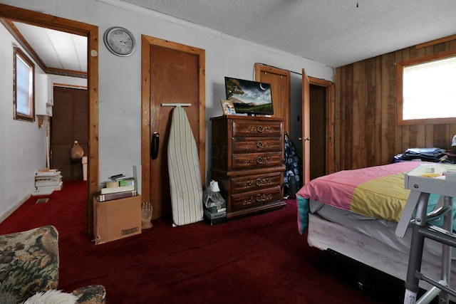 carpeted bedroom featuring wooden walls and a textured ceiling