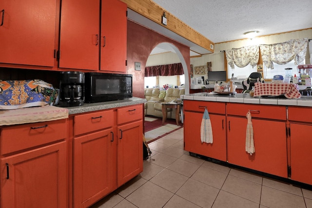 kitchen featuring a textured ceiling, tile countertops, and light tile patterned flooring