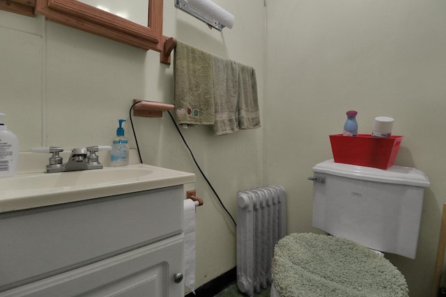 bathroom with radiator heating unit, vanity, and toilet