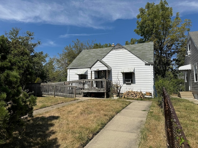 view of front of property with a deck and a front lawn