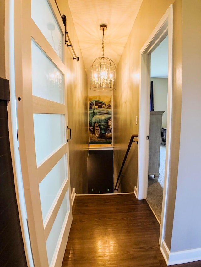 corridor with a chandelier and dark hardwood / wood-style flooring