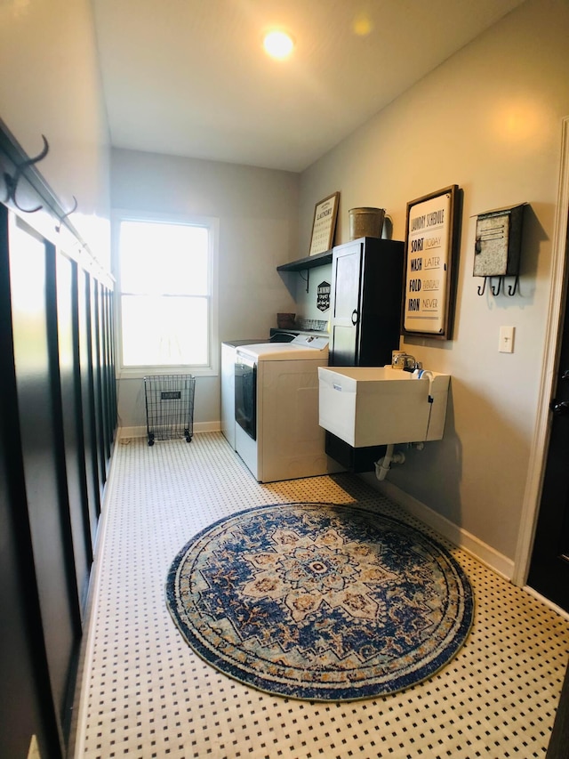 washroom featuring washer and clothes dryer, sink, and light carpet