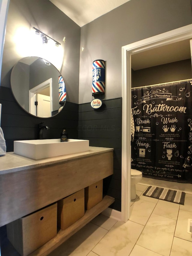 bathroom with tile patterned flooring, vanity, and toilet