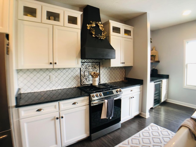 kitchen featuring decorative backsplash, custom exhaust hood, beverage cooler, white cabinets, and stainless steel range with gas stovetop