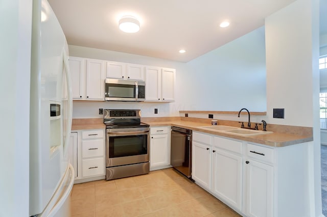 kitchen with light tile patterned floors, sink, white cabinetry, and appliances with stainless steel finishes