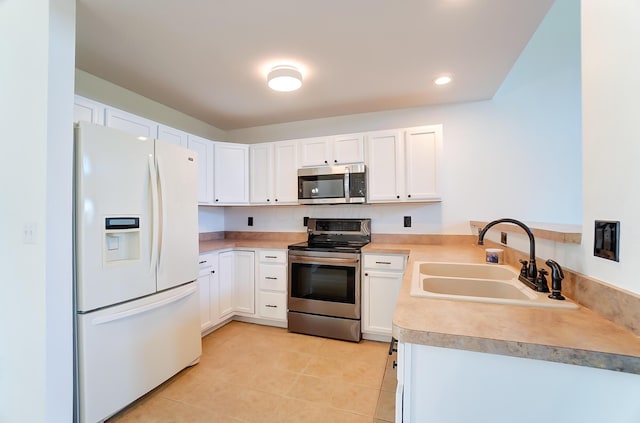 kitchen featuring white cabinets, sink, stainless steel appliances, and light tile patterned flooring