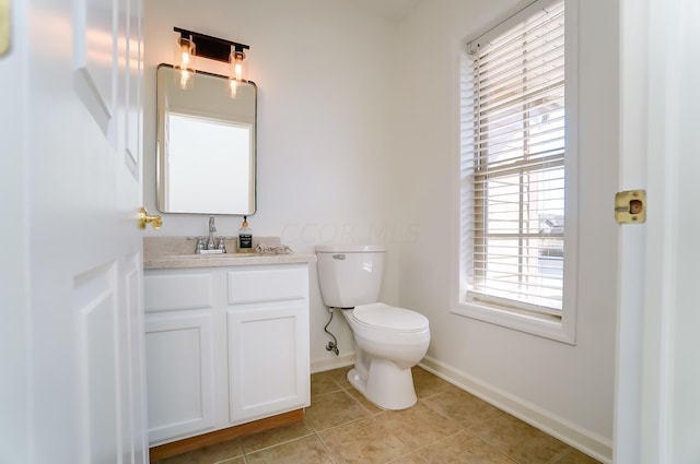 bathroom with toilet, vanity, and tile patterned floors