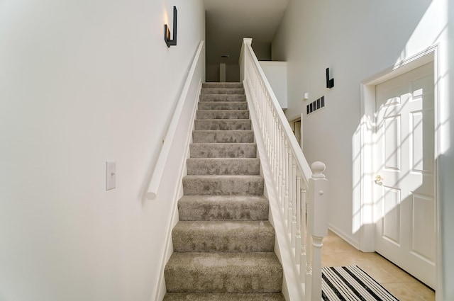 staircase featuring tile patterned flooring