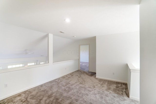 carpeted empty room featuring ceiling fan and vaulted ceiling