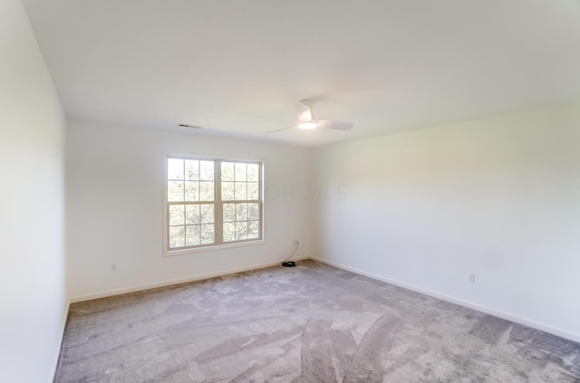 carpeted spare room featuring ceiling fan