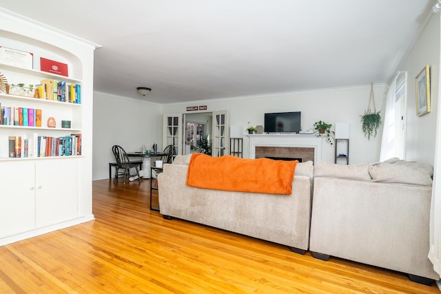 living room featuring hardwood / wood-style flooring and crown molding