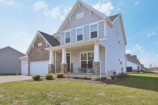 craftsman inspired home with a porch, a garage, and a front lawn