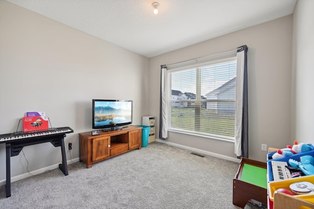 rec room with lofted ceiling, light carpet, visible vents, and baseboards