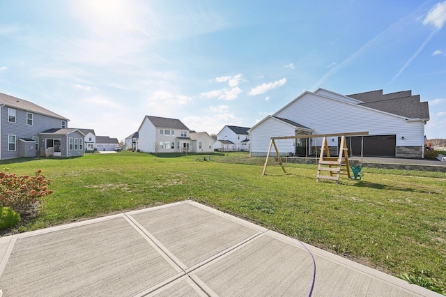 view of yard featuring a garage, a residential view, and a playground