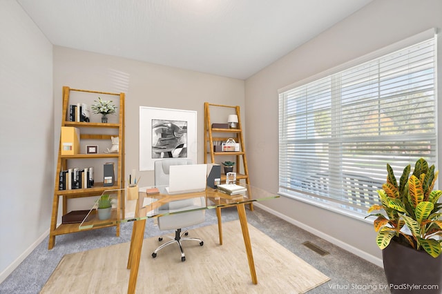 office area featuring light colored carpet, visible vents, and baseboards