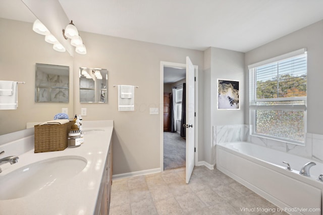 full bath with a bath, double vanity, baseboards, and a sink