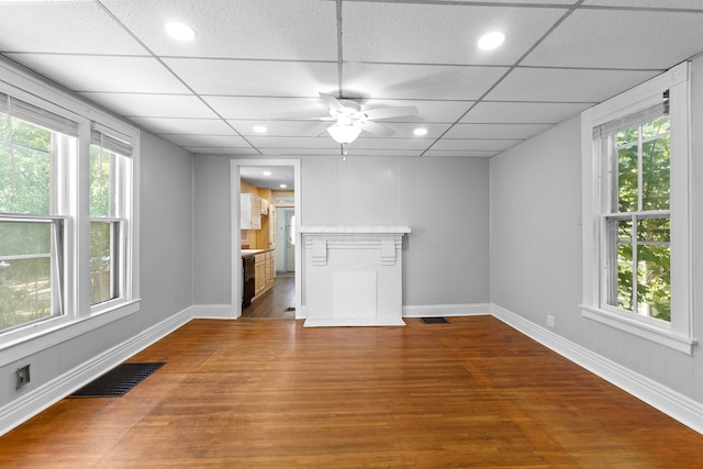 unfurnished living room featuring wood-type flooring, a paneled ceiling, and ceiling fan