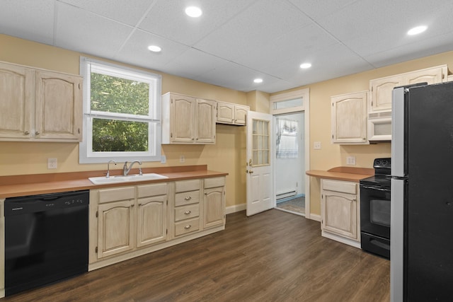 kitchen featuring a drop ceiling, black appliances, sink, baseboard heating, and dark hardwood / wood-style flooring