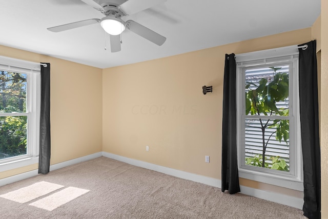 carpeted empty room featuring a wealth of natural light and ceiling fan