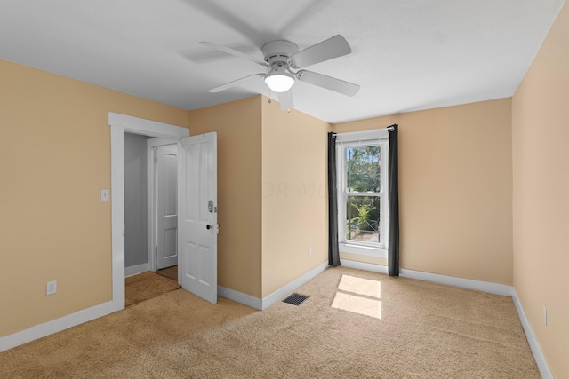 carpeted spare room featuring ceiling fan