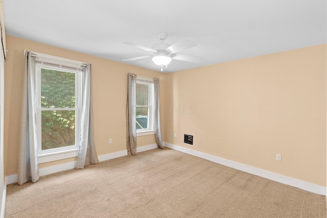 carpeted spare room featuring ceiling fan